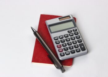 black and silver calculator beside black pen